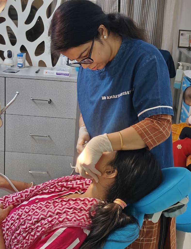 Dr. Amrata performing dental procedure on adult patient